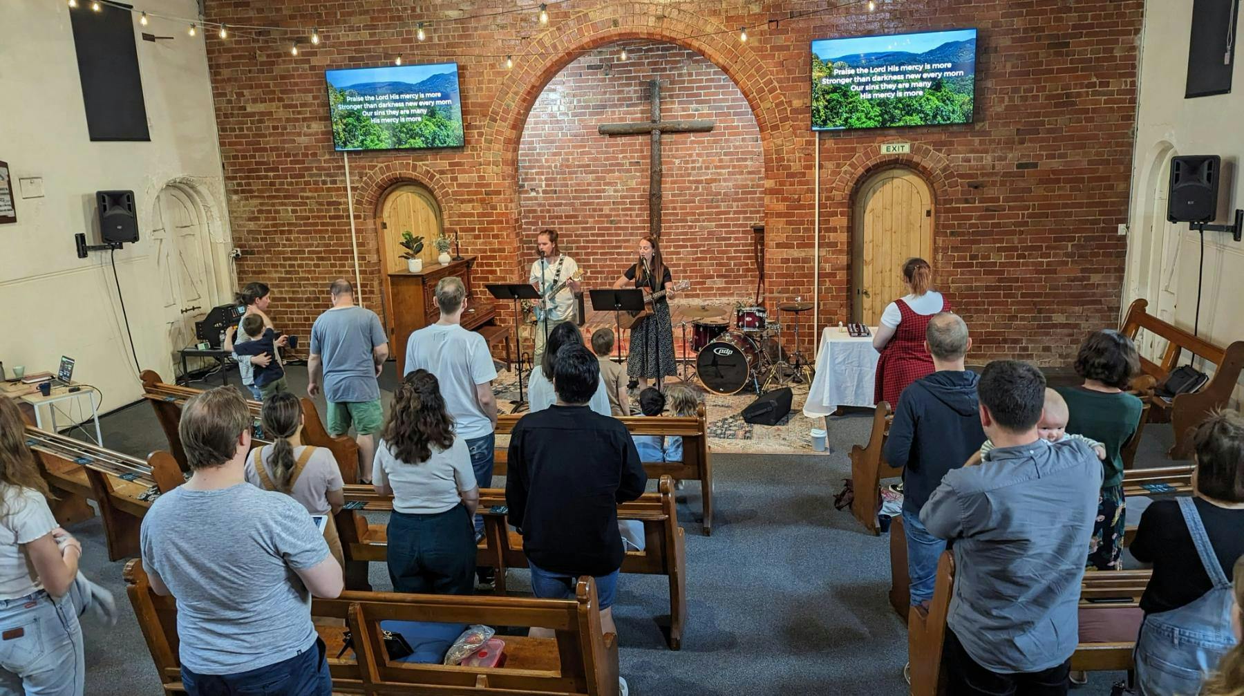 A group of people standing and singing in a church building